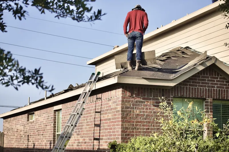 Professional roofer working on a residential roof in West Cambridge